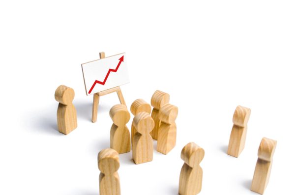 The leader is standing near the graph with a red up arrow speaks a speech addressing a crowd of people. Business concept of leader and leadership qualities, crowd management, political debate