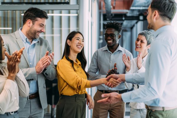 Business people shaking hands in the office. Business persons handshaking during a meeting in modern office.